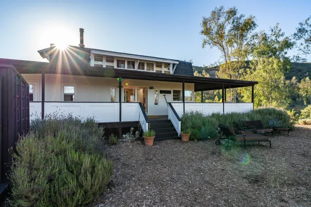 a view of a house with backyard and sitting area