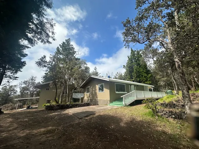 a view of a house with a large tree and a yard