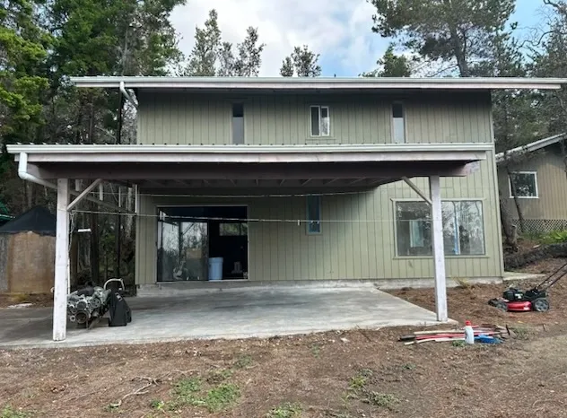 a view of a house with a patio and a yard