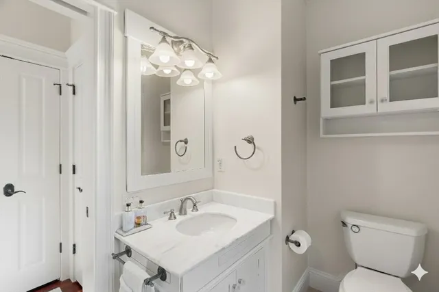 a bathroom with a toilet sink and mirror