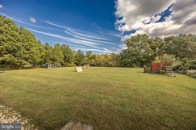 an aerial view of a house with swimming pool and outdoor seating