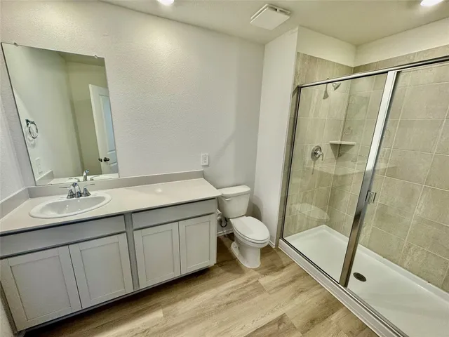 a bathroom with a double vanity sink toilet and shower