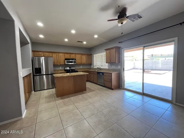 a kitchen with stainless steel appliances granite countertop a stove top oven a sink a refrigerator and a granite counter top