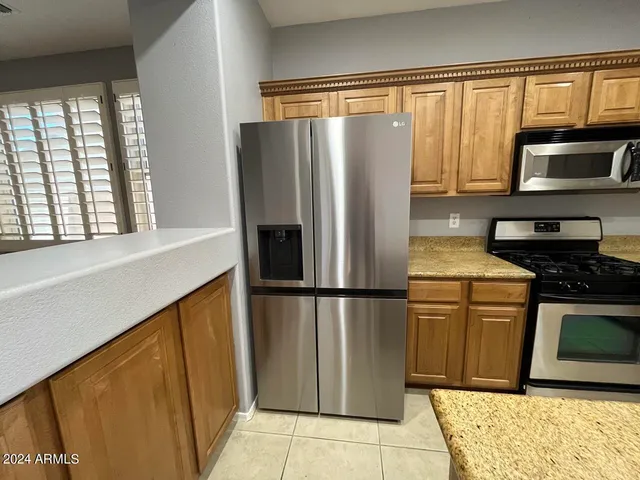 a kitchen with stainless steel appliances granite countertop a refrigerator and a stove top oven