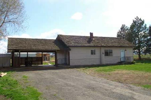 15390 Fisk Road Yakima, WA 98908 - Photo 1 of 7 a front view of a house with a garden