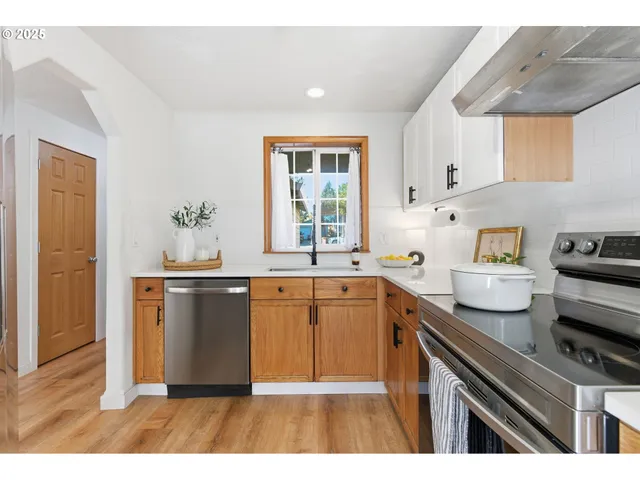 a kitchen with granite countertop a sink cabinets and stainless steel appliances