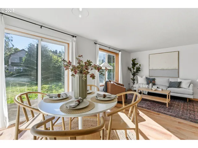 a dining room with furniture a large window and a rug