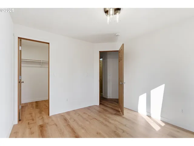 a view of an empty room with wooden floor
