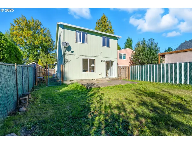 a white house with a small yard and fence