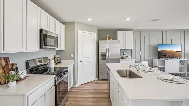 a kitchen with granite countertop a sink stove and refrigerator