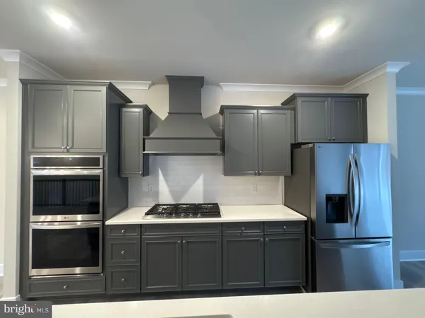 a kitchen with kitchen island a counter and a refrigerator