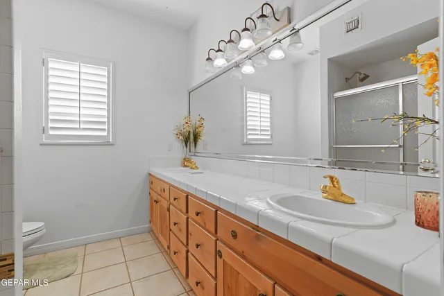 a bathroom with a sink a faucet a light fixture and a window