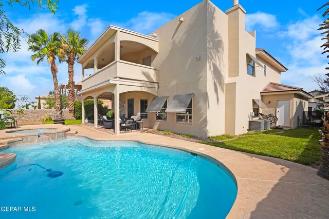 a front view of a house with swimming pool having outdoor seating