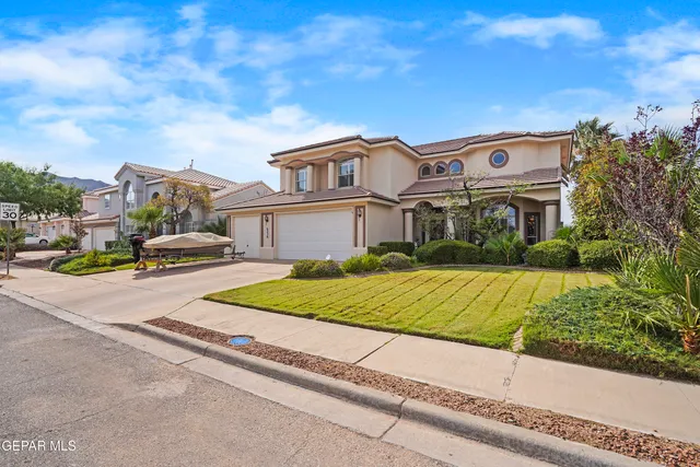 a front view of a house with a garden and trees