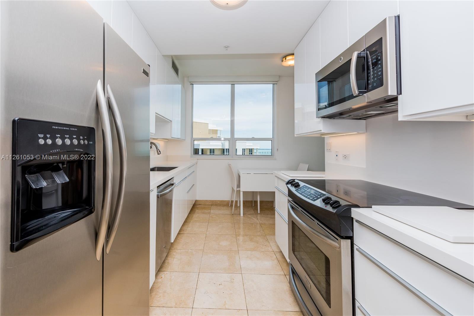 801 Brickell Key Boulevard, Unit 2401 Miami, FL 33131 - Photo 11 of 35 a kitchen with stainless steel appliances granite countertop a stove a sink and a refrigerator