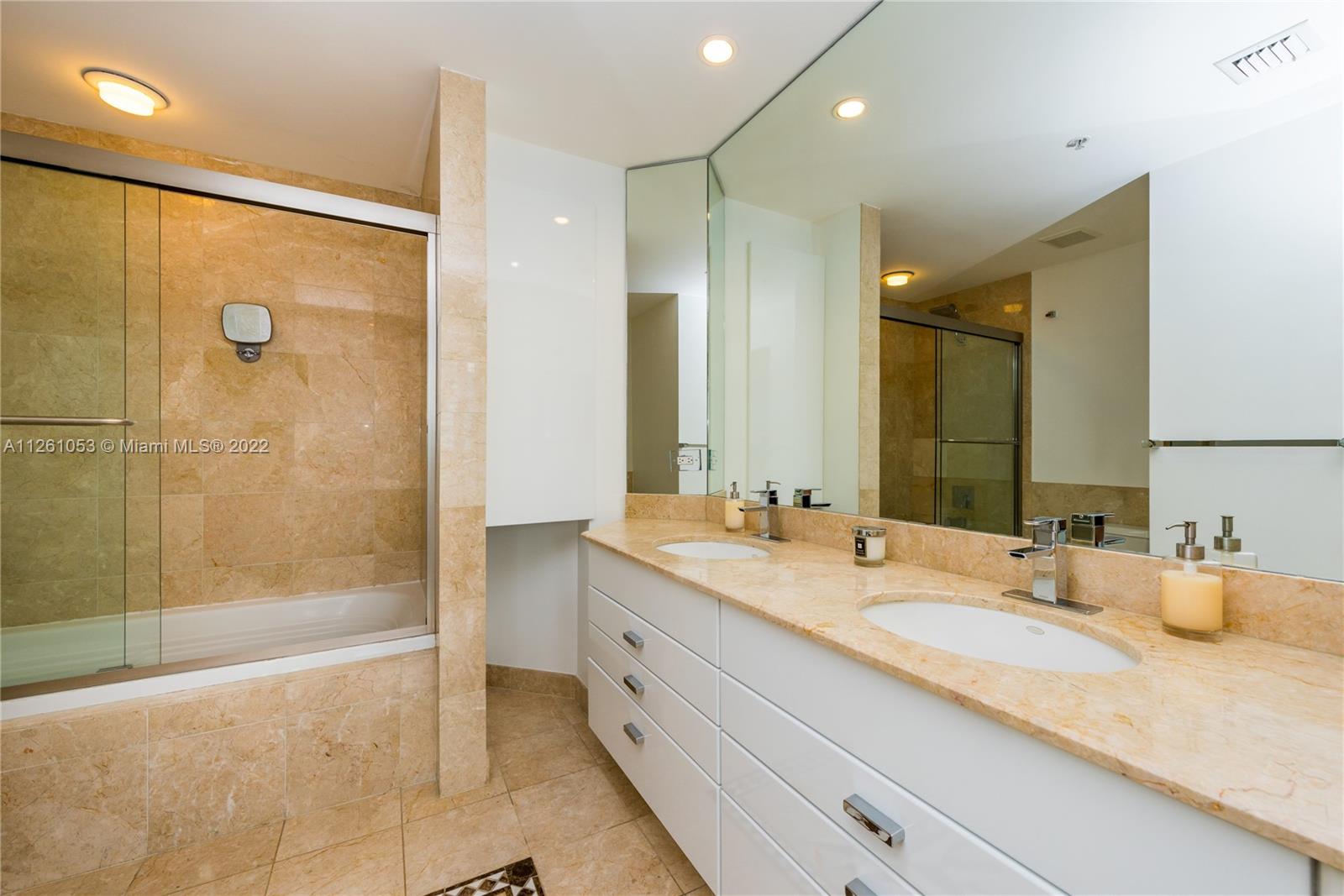 801 Brickell Key Boulevard, Unit 2401 Miami, FL 33131 - Photo 19 of 35 a bathroom with a granite countertop sink mirror and shower