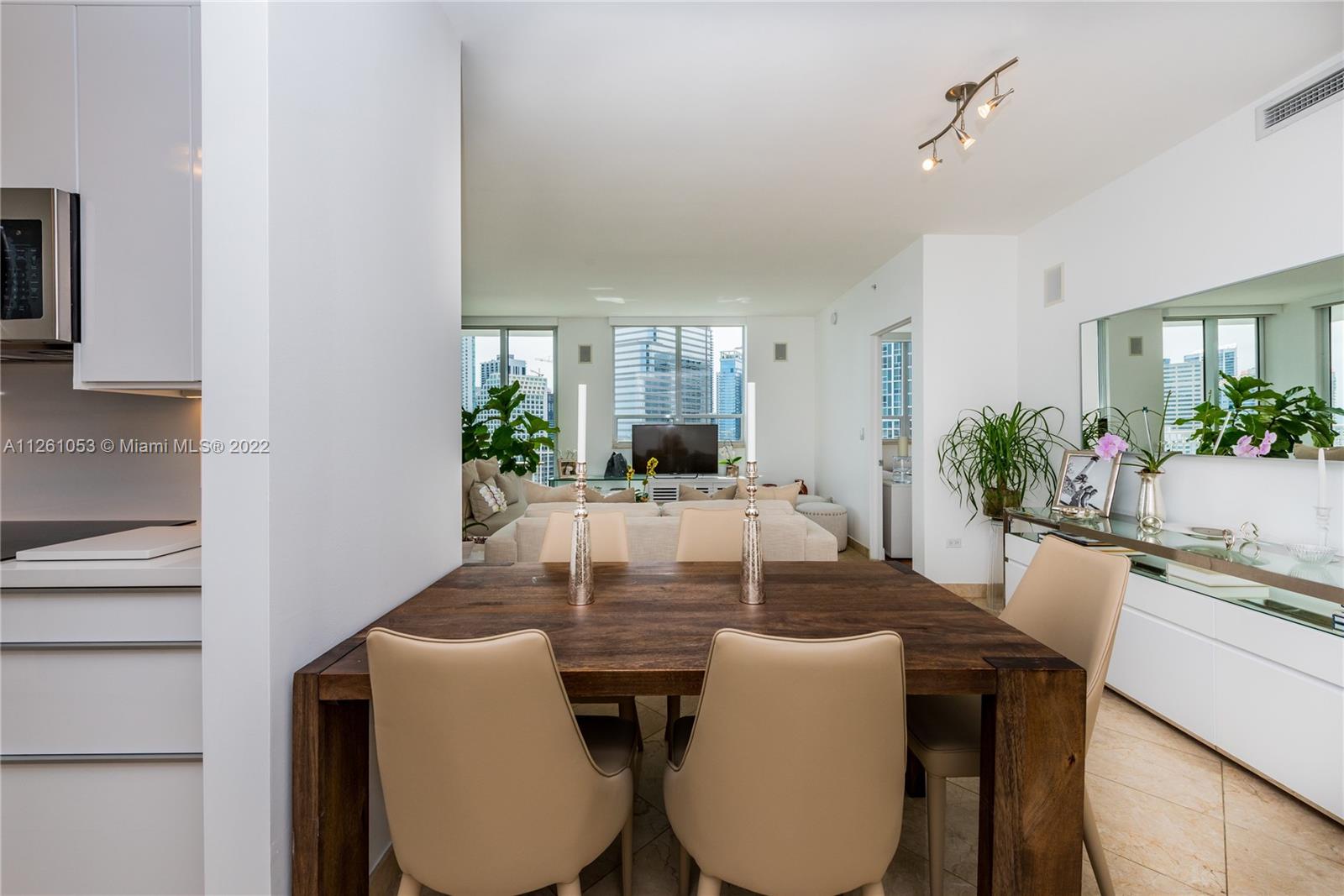801 Brickell Key Boulevard, Unit 2401 Miami, FL 33131 - Photo 3 of 35 a view of a dining room with furniture and wooden floor