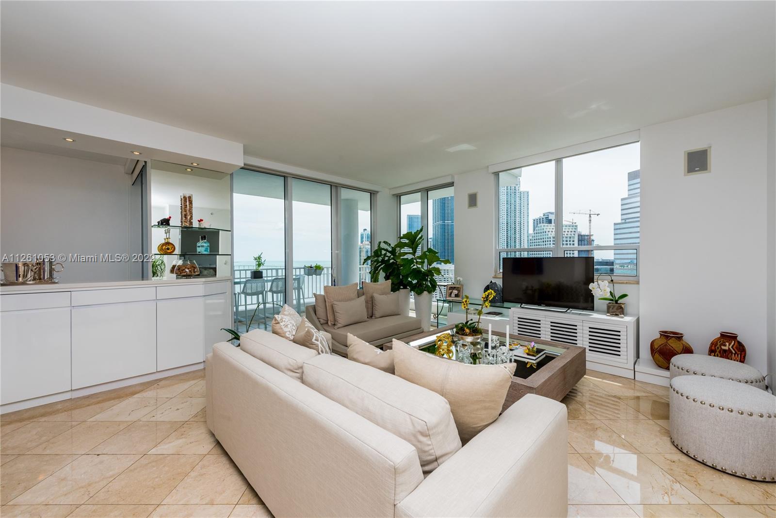 801 Brickell Key Boulevard, Unit 2401 Miami, FL 33131 - Photo 4 of 35 a living room with furniture and a flat screen tv