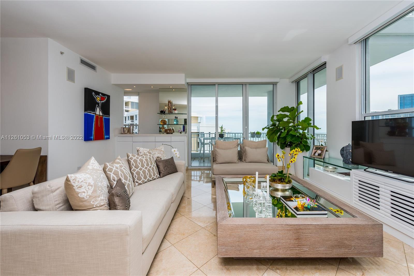 801 Brickell Key Boulevard, Unit 2401 Miami, FL 33131 - Photo 5 of 35 a living room with furniture and a flat screen tv