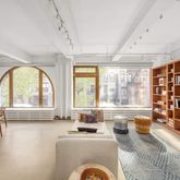 a view of a livingroom with furniture staircase and a large window