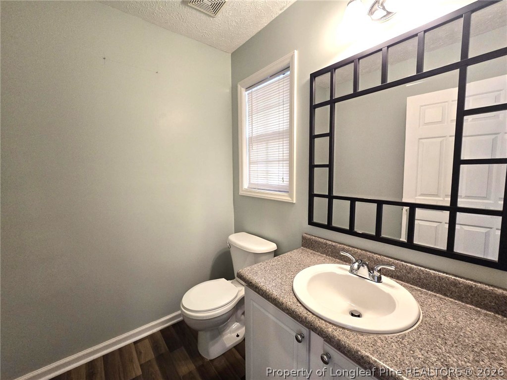 5527 Rising Ridge Drive Hope Mills, NC 28348 - Photo 18 of 35 a bathroom with a granite countertop toilet sink mirror and vanity