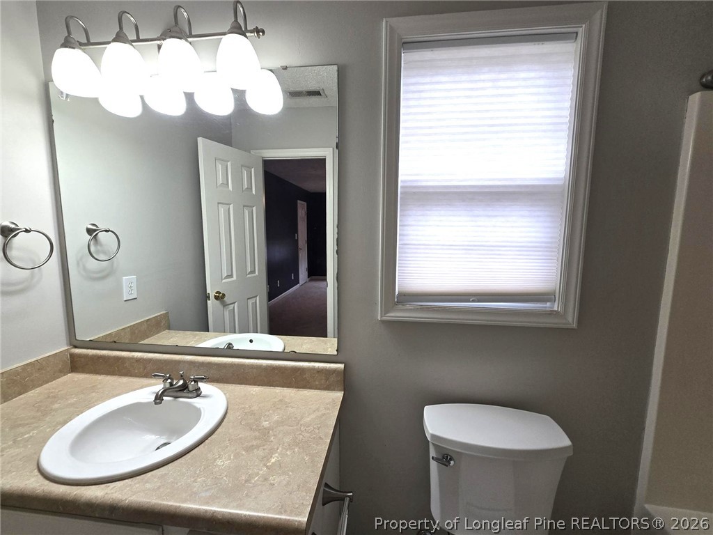 5527 Rising Ridge Drive Hope Mills, NC 28348 - Photo 29 of 35 a bathroom with a toilet sink and mirror
