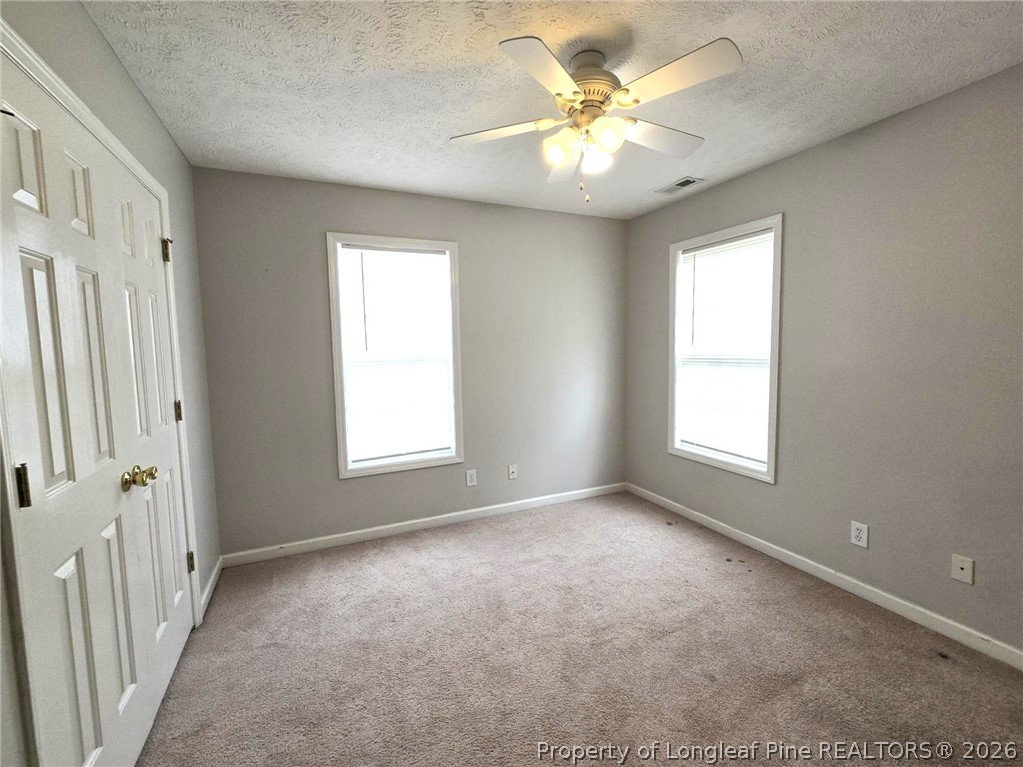5527 Rising Ridge Drive Hope Mills, NC 28348 - Photo 31 of 35 an empty room with windows and ceiling fan