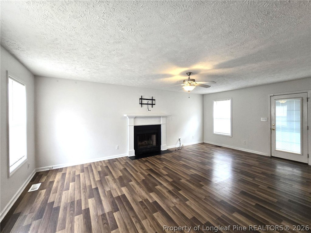 5527 Rising Ridge Drive Hope Mills, NC 28348 - Photo 5 of 35 wooden floor fireplace and windows in an empty room