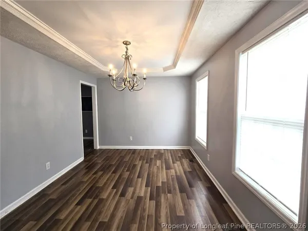 a view of a room with wooden floor and chandelier