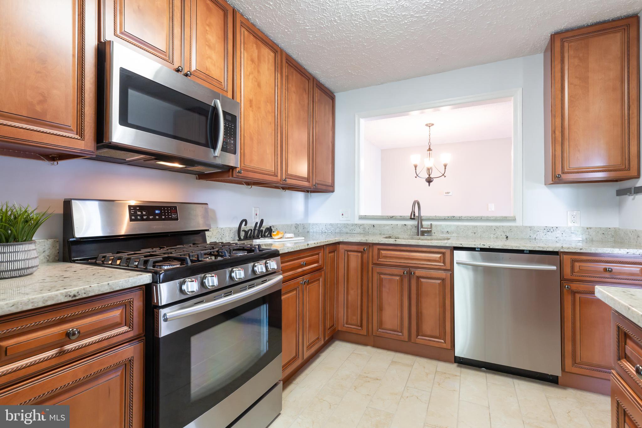 2233 Hunter's Run Drive Reston, VA 20191 - Photo 3 of 50 a kitchen with stainless steel appliances granite countertop a stove a sink and a microwave