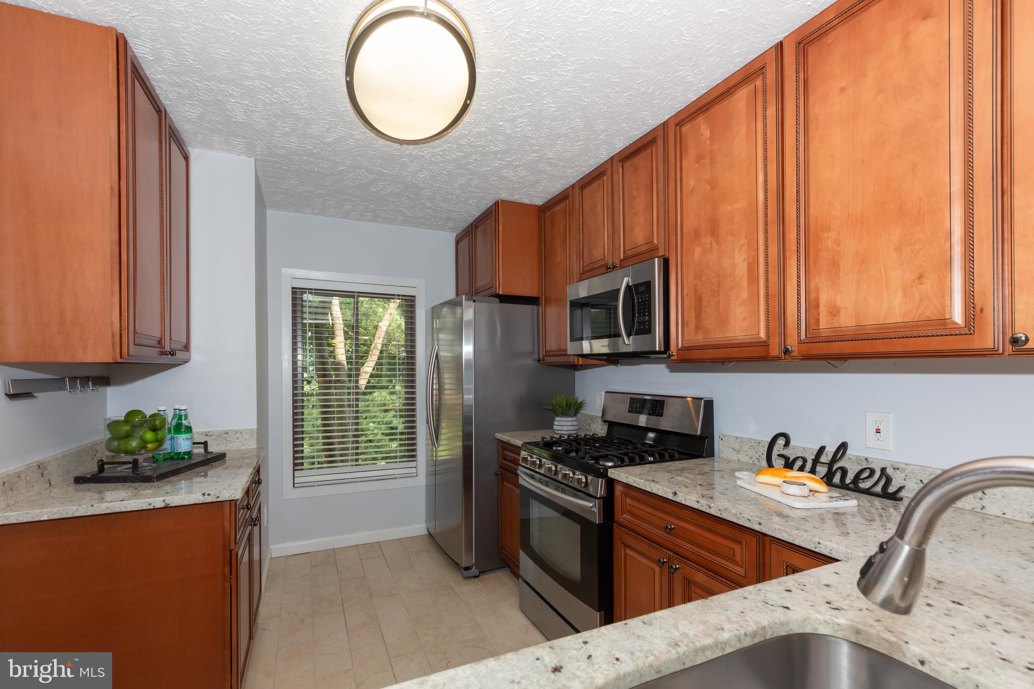 2233 Hunter's Run Drive Reston, VA 20191 - Photo 10 of 50 a kitchen with stainless steel appliances granite countertop a stove a sink and a microwave
