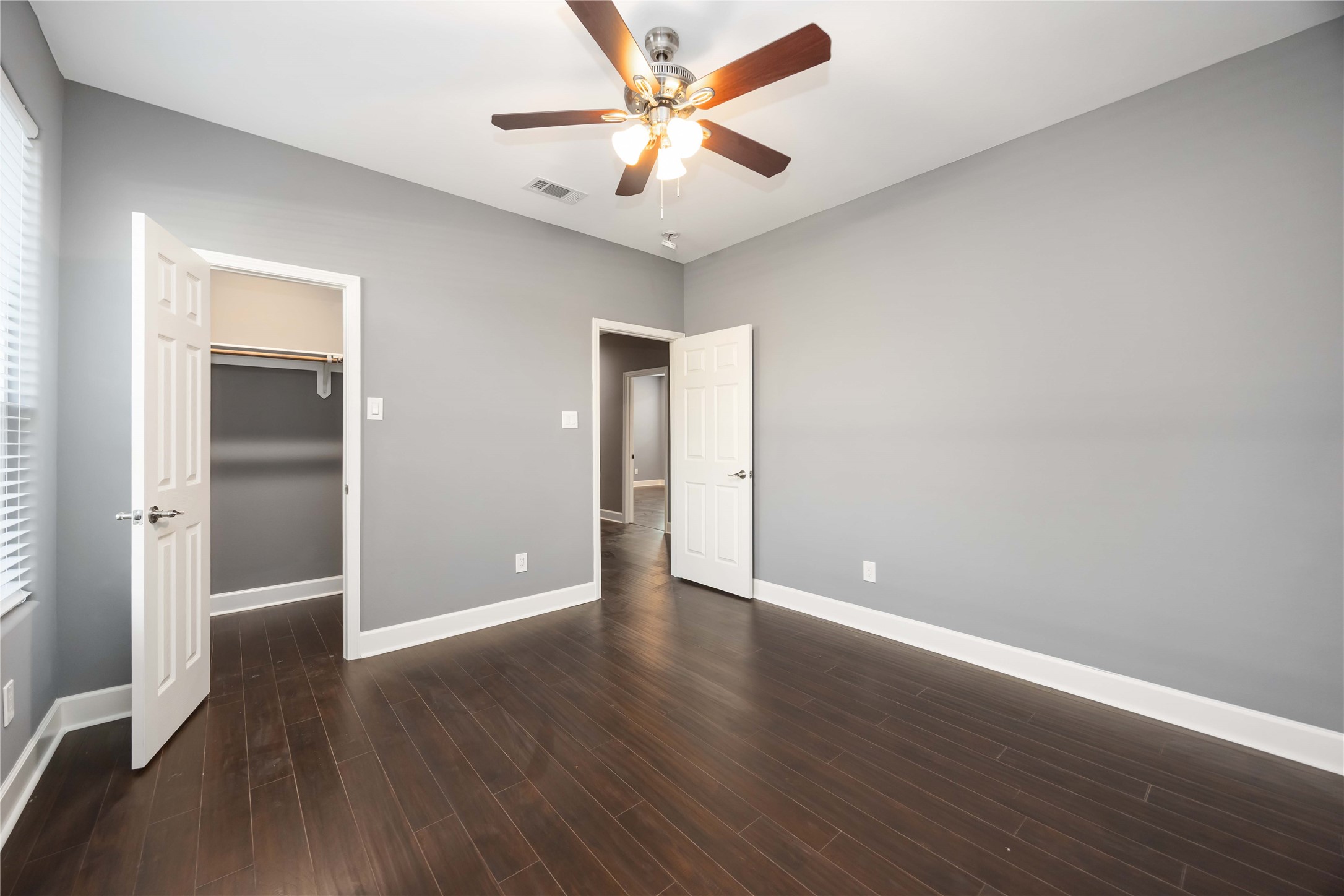 813 Fortune Street Houston, TX 77088 - Photo 13 of 27 an empty room with wooden floor and a ceiling fan