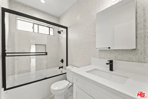 a bathroom with a sink a toilet and a shower