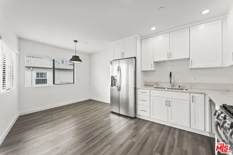 a kitchen with granite countertop white cabinets and white appliances