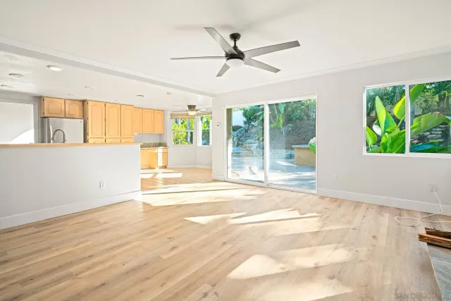 a room with wooden floor pool table and windows
