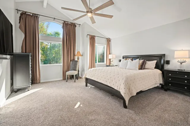 a spacious bathroom with double vanity a mirror a bathtub and a window