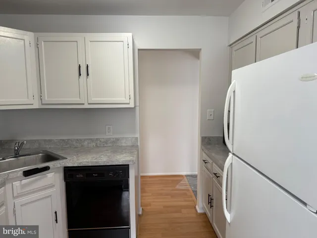 a white refrigerator freezer and a wooden floor