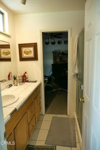 a bathroom with a granite countertop sink a mirror and a shower