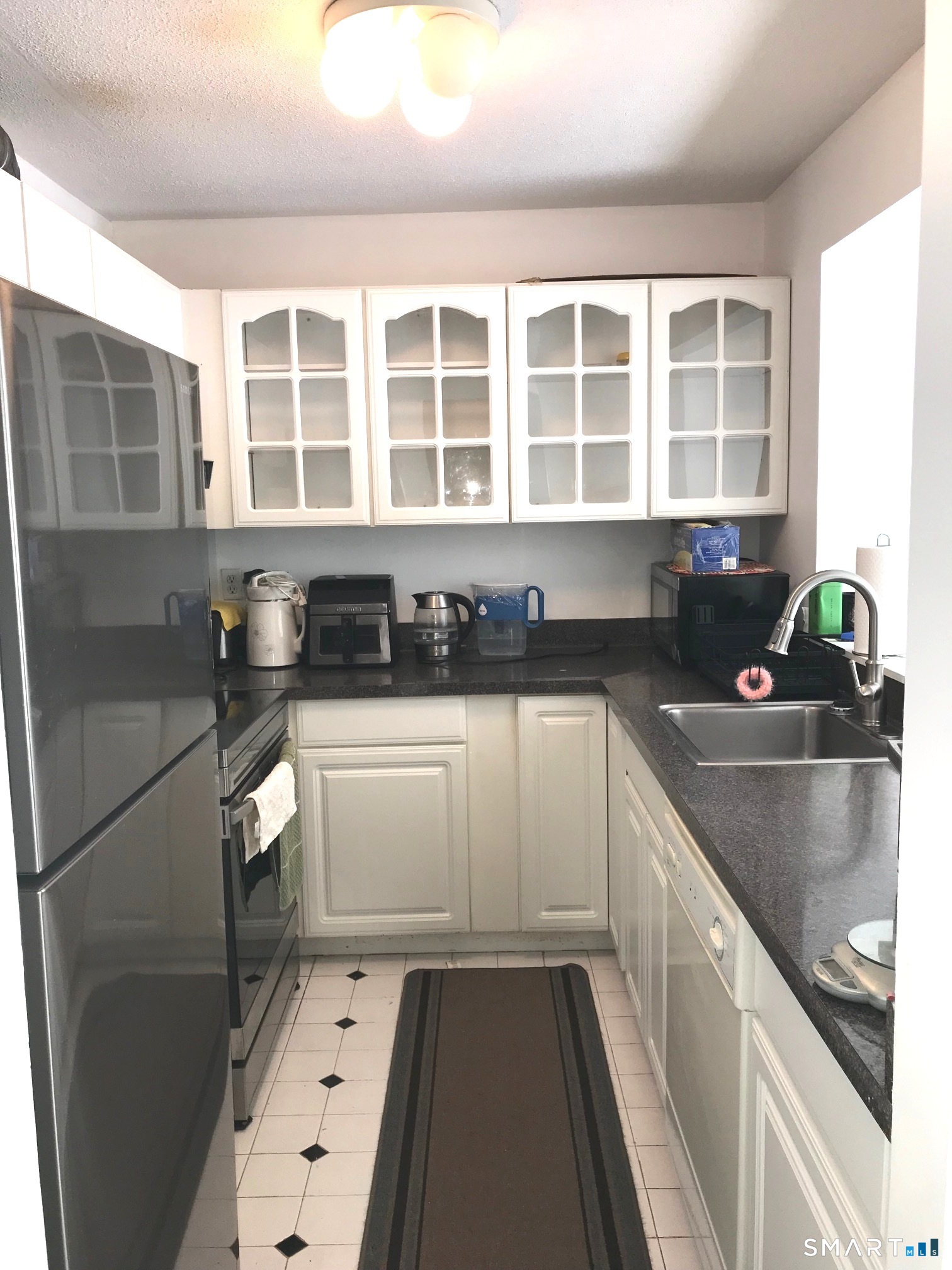 175 Mill Pond Road, Unit 346 Hamden, CT 06514 - Photo 8 of 18 a kitchen with granite countertop a sink and a stove top oven