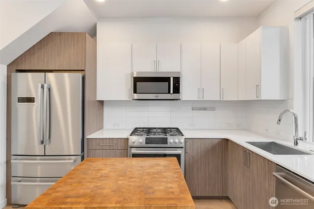 a kitchen with white cabinets and stainless steel appliances