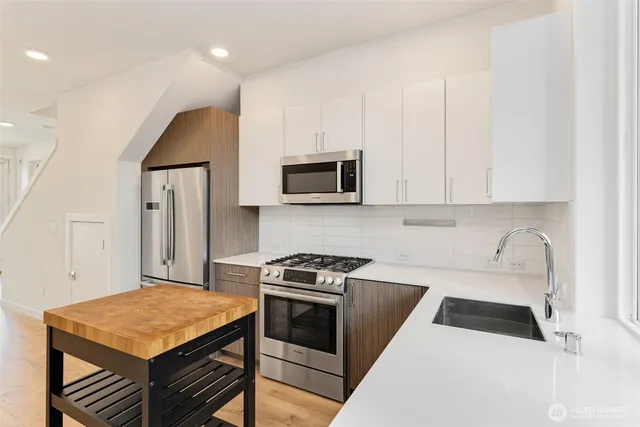 a kitchen with cabinets and steel appliances