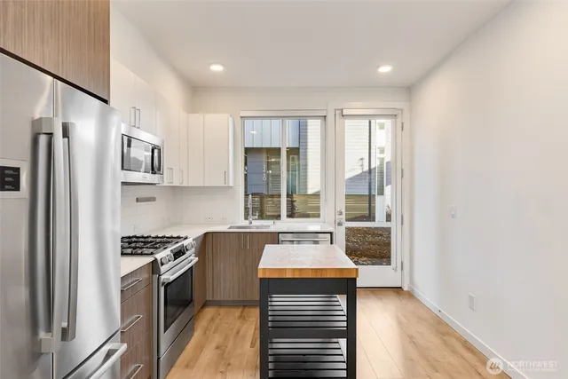 a kitchen with stainless steel appliances a refrigerator and a stove top oven