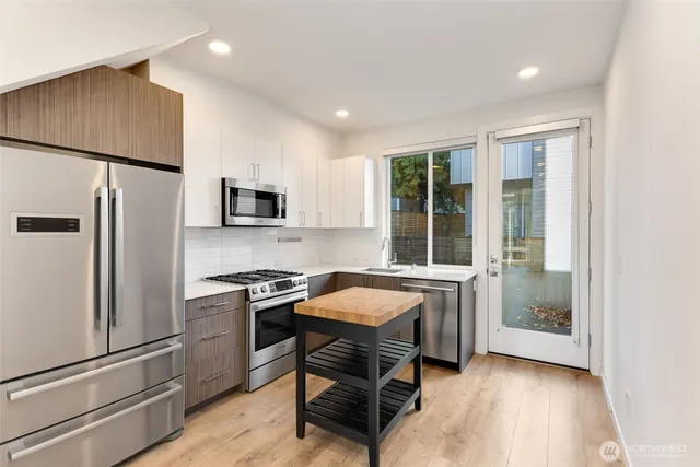 a kitchen with a refrigerator a stove a sink and a window