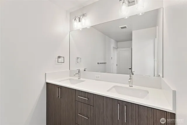 a bathroom with a double vanity sink and mirror