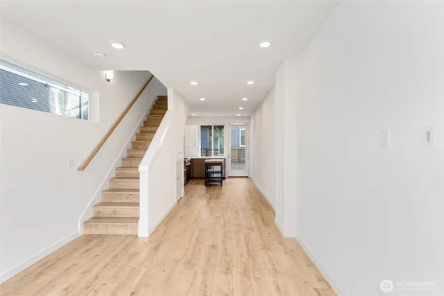 a view of a hallway with wooden floor and staircase