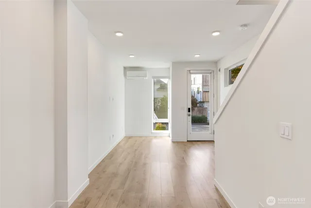 a view of a hallway with wooden floor and staircase