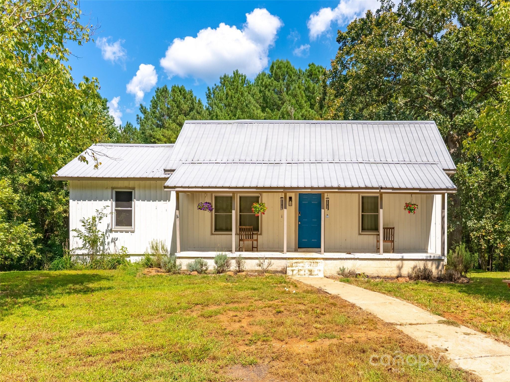 1343 Solen Williams Road Tryon, NC 28782 - Photo 1 of 17 a front view of a house with a garden and tree