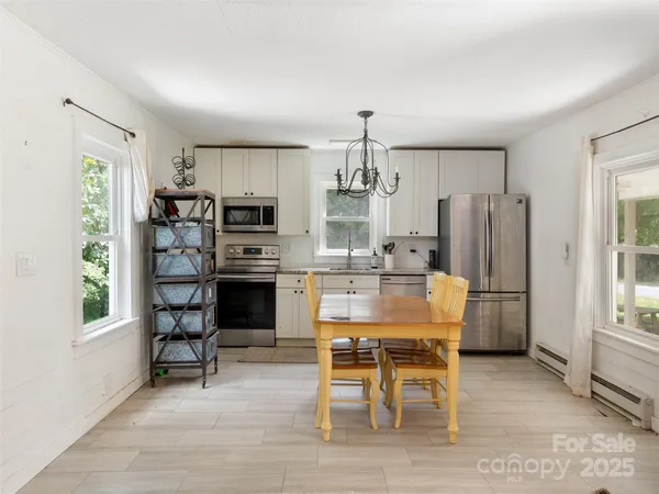 a view of a kitchen with refrigerator and wooden floor