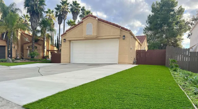 a view of backyard of house with garage and trees