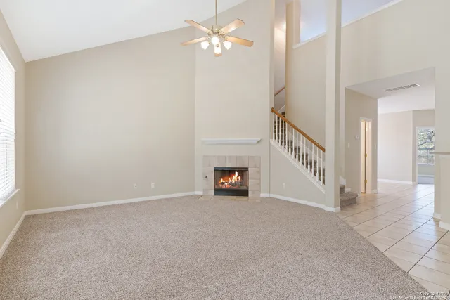 a view of an empty room with a fireplace and a window